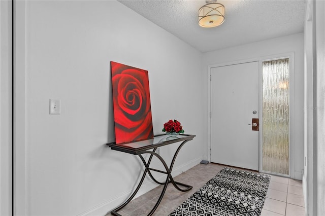 tiled entryway with a textured ceiling