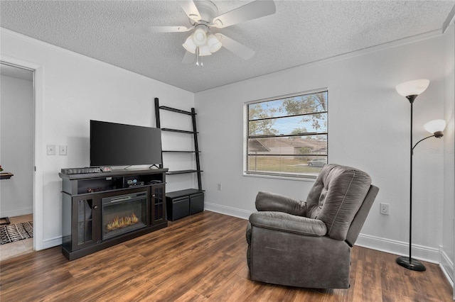 sitting room featuring dark wood-type flooring, ceiling fan, and a textured ceiling