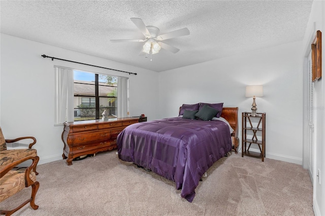 bedroom featuring ceiling fan, light colored carpet, and a textured ceiling