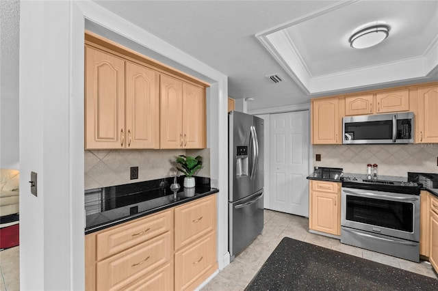 kitchen with stainless steel appliances, light brown cabinetry, and a tray ceiling