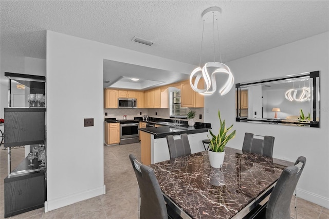 dining space with a raised ceiling, sink, and a textured ceiling