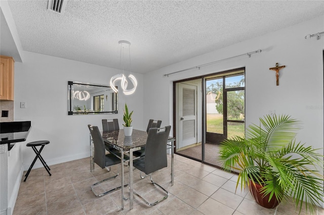 dining space with light tile patterned flooring, a chandelier, and a textured ceiling