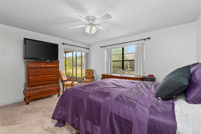 carpeted bedroom with ceiling fan and a textured ceiling