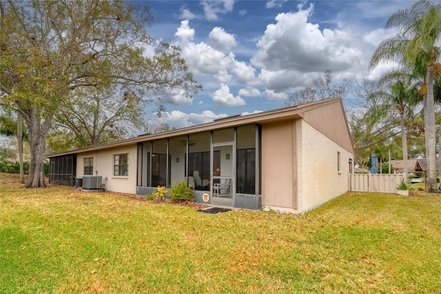 back of house featuring central AC, a lawn, and a sunroom