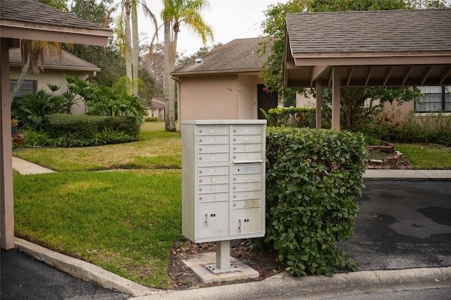 view of home's community featuring a mail area and a lawn