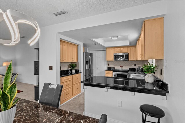 20 Sylvia Pl, Oldsmar, FL 34677 - kitchen featuring appliances with stainless steel finishes, dark countertops, light brown cabinetry, light marble finish flooring, and tasteful backsplash