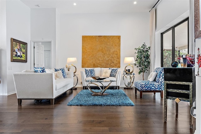 sitting room featuring dark hardwood / wood-style flooring and a towering ceiling