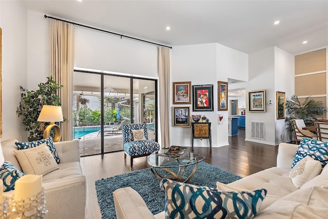 living room featuring hardwood / wood-style flooring and a high ceiling