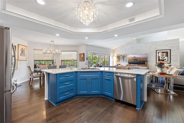 kitchen with blue cabinets, appliances with stainless steel finishes, an inviting chandelier, and a tray ceiling