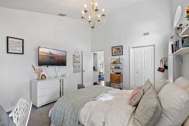 bedroom featuring a notable chandelier, a closet, and a high ceiling