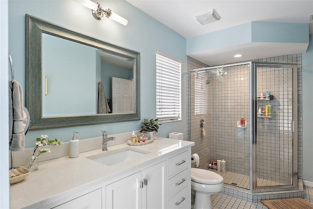 bathroom with vanity, tile patterned flooring, toilet, and walk in shower