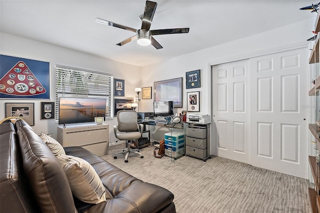 carpeted home office featuring ceiling fan