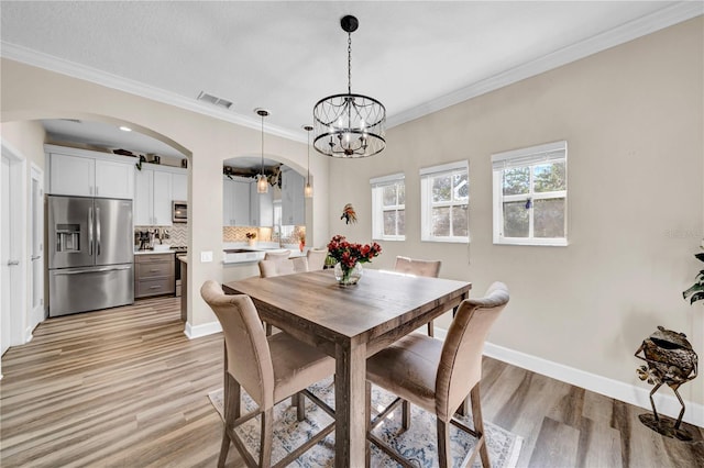 dining room featuring ornamental molding and light hardwood / wood-style flooring