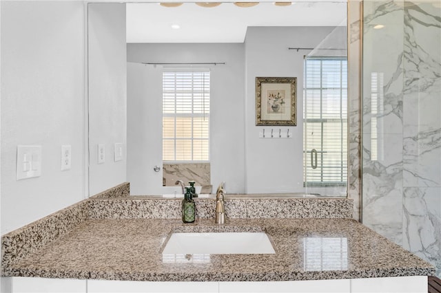 bathroom with walk in shower and vanity