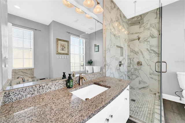 bathroom with vanity, toilet, and a shower with door