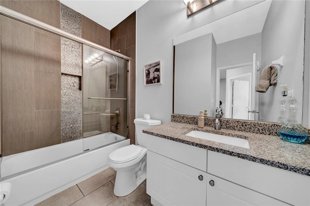 full bathroom with tile patterned flooring, vanity, shower / bath combination with glass door, and toilet