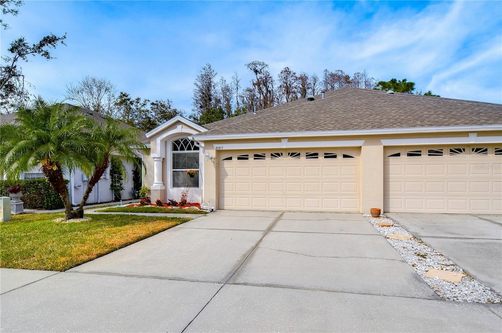 ranch-style home featuring a garage and a front yard