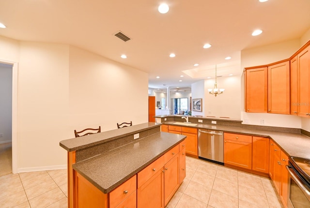 kitchen featuring a kitchen island, a breakfast bar, sink, light tile patterned floors, and stainless steel appliances