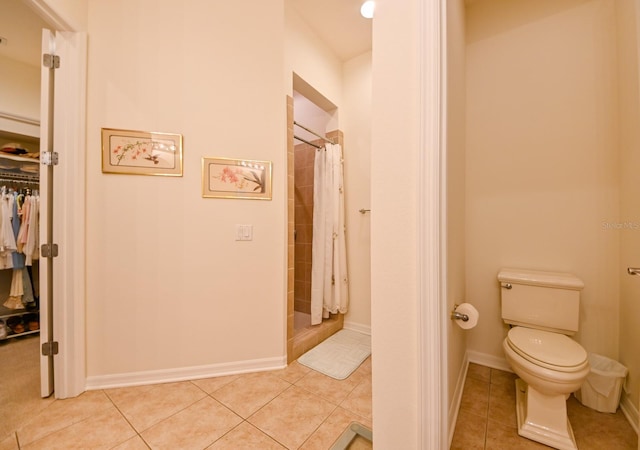 bathroom with walk in shower, tile patterned floors, and toilet