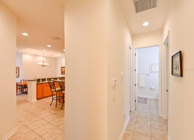 corridor featuring a chandelier, sink, and light tile patterned floors