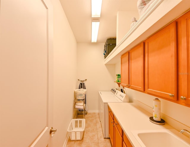 washroom featuring cabinets, sink, light tile patterned floors, and washing machine and clothes dryer