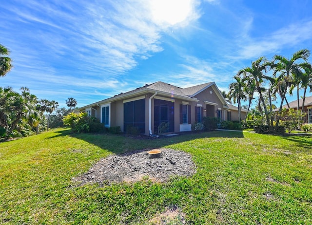 view of home's exterior with a sunroom and a yard