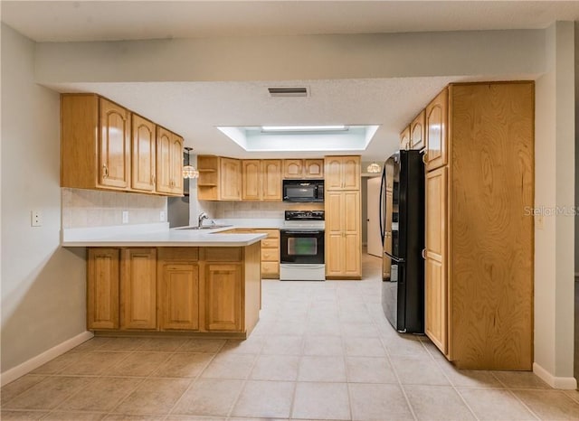 kitchen featuring backsplash, sink, black appliances, and kitchen peninsula