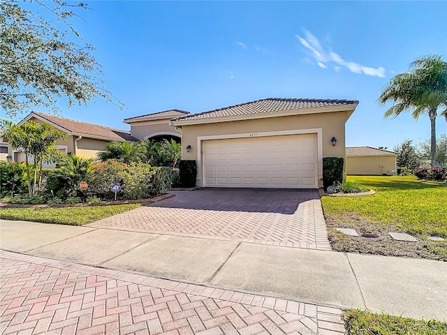 mediterranean / spanish-style home featuring a garage and a front yard