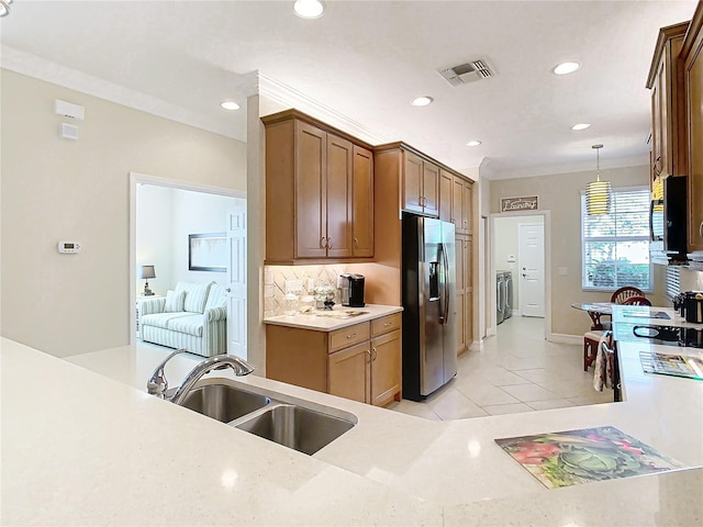 kitchen with tasteful backsplash, sink, hanging light fixtures, light tile patterned floors, and stainless steel refrigerator with ice dispenser