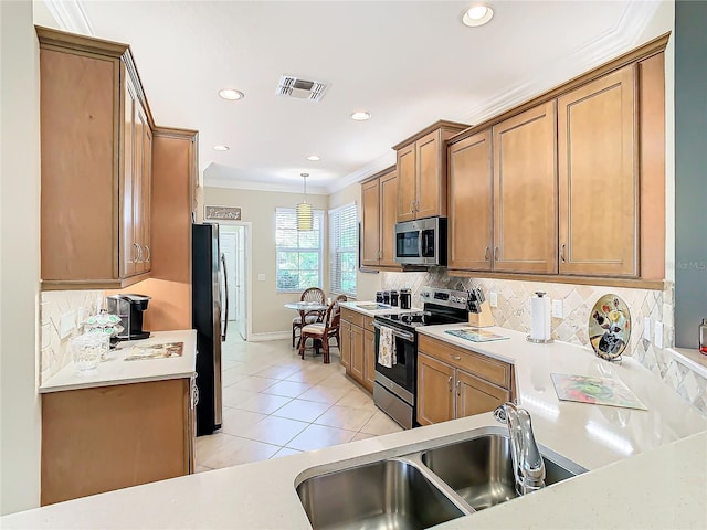 kitchen with sink, crown molding, light tile patterned floors, hanging light fixtures, and stainless steel appliances