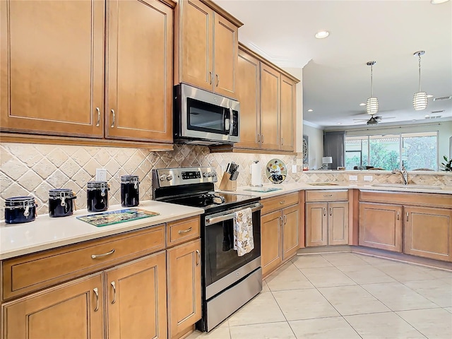 kitchen featuring pendant lighting, sink, backsplash, light tile patterned floors, and stainless steel appliances