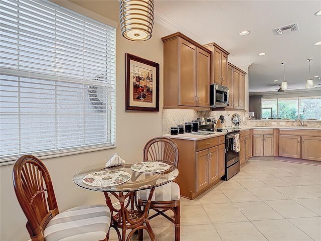 kitchen featuring sink, light tile patterned floors, stainless steel appliances, tasteful backsplash, and decorative light fixtures