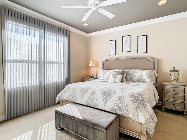 carpeted bedroom featuring crown molding and ceiling fan