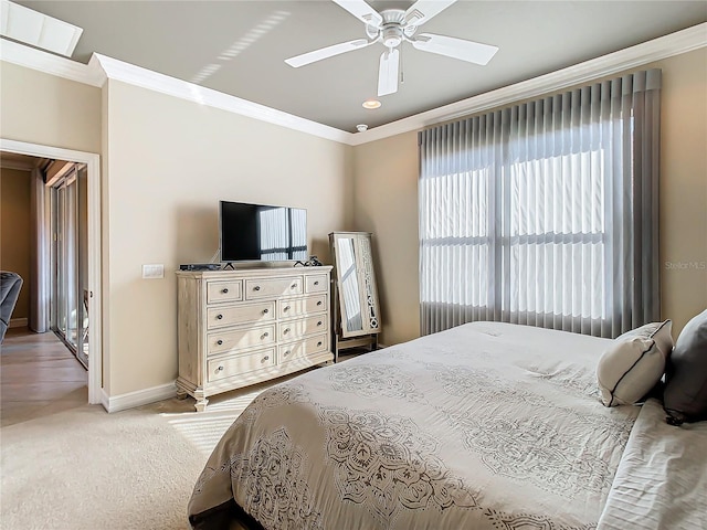 carpeted bedroom featuring crown molding and ceiling fan