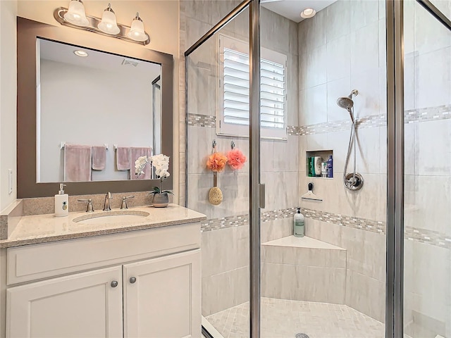 bathroom featuring vanity and a shower with shower door