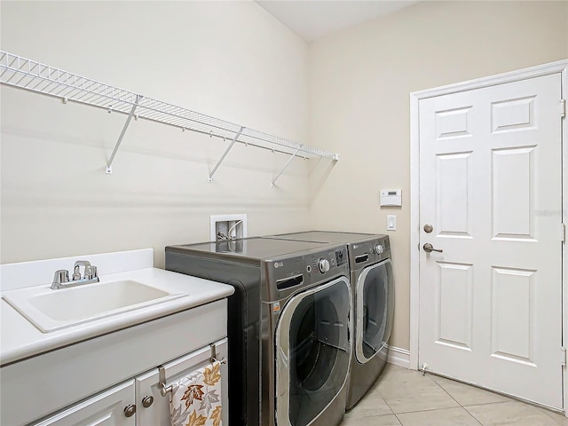 washroom with light tile patterned flooring, independent washer and dryer, and sink