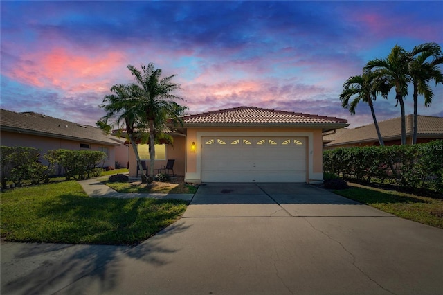 view of front of home with a garage and a yard