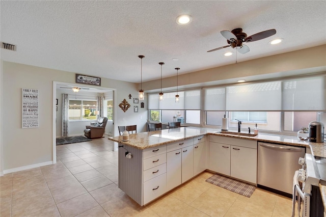 kitchen with sink, kitchen peninsula, stainless steel appliances, light stone countertops, and white cabinets