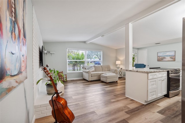 living room featuring light hardwood / wood-style flooring and vaulted ceiling with beams