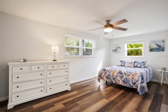 bedroom with multiple windows, dark wood-type flooring, and ceiling fan