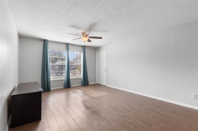 empty room featuring hardwood / wood-style flooring, a textured ceiling, and ceiling fan