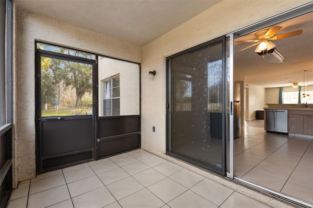 unfurnished sunroom with plenty of natural light, sink, and ceiling fan