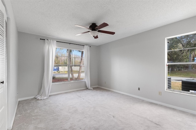 unfurnished room featuring ceiling fan, light carpet, and a textured ceiling