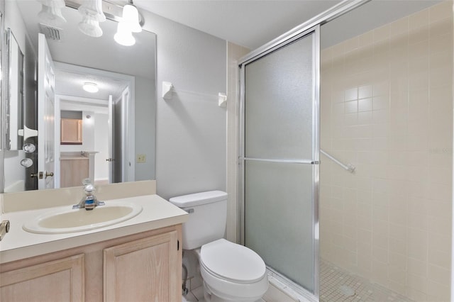 bathroom with an enclosed shower, vanity, and toilet