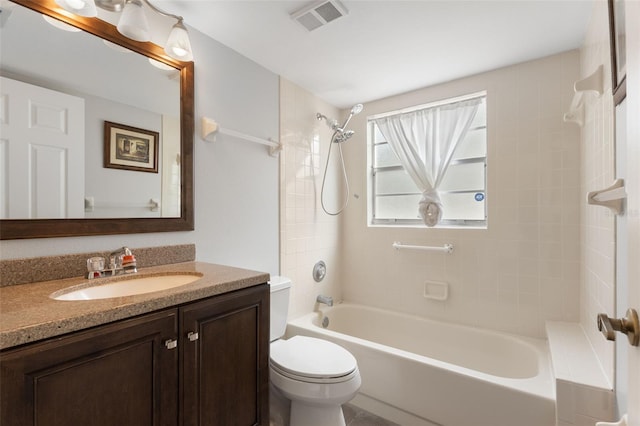 full bathroom featuring vanity, tiled shower / bath combo, and toilet