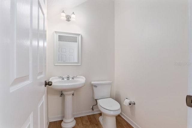 bathroom featuring hardwood / wood-style floors and toilet