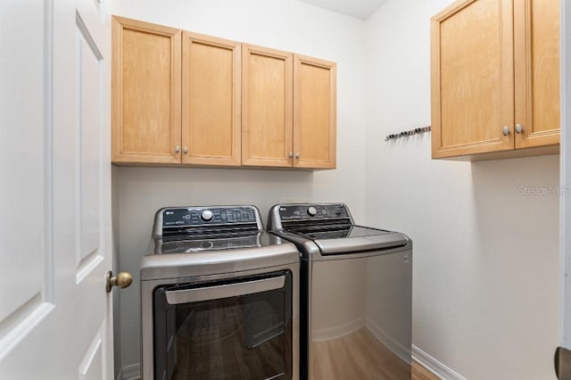 washroom with cabinets and washer and dryer