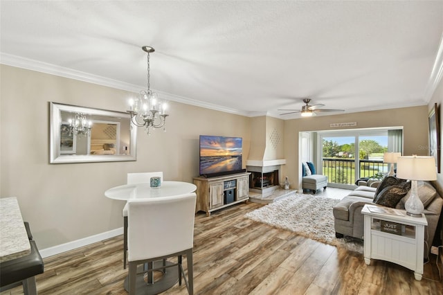 living room with ceiling fan, ornamental molding, and wood-type flooring