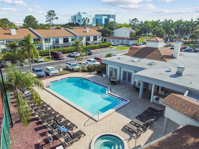 view of pool with a hot tub, french doors, and a patio area