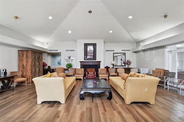 living room featuring lofted ceiling and light hardwood / wood-style floors